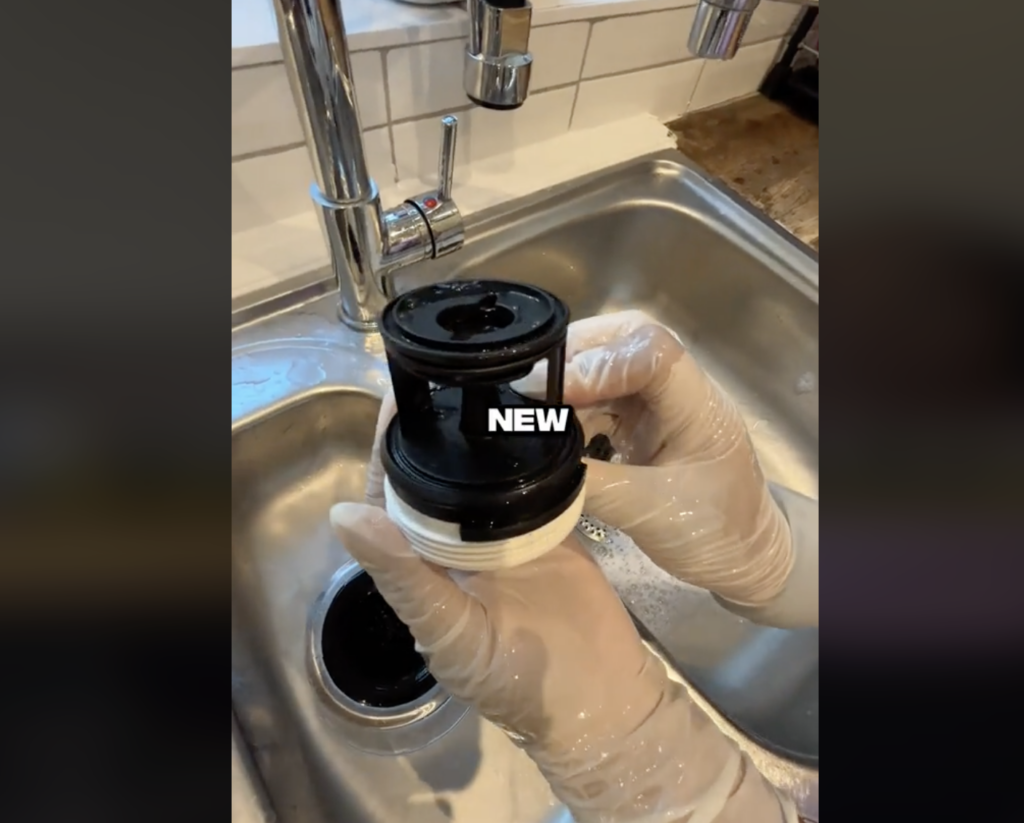 woman washing washing machine filter in the sink